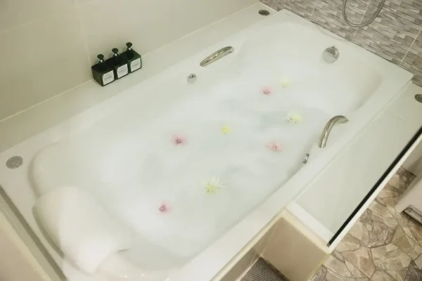 Luxurious bathtub with flower petals, in a modern wellness spa bathroom, perfect for relaxation and health treatments - In Villa Spa Sanpudard Wellness Club