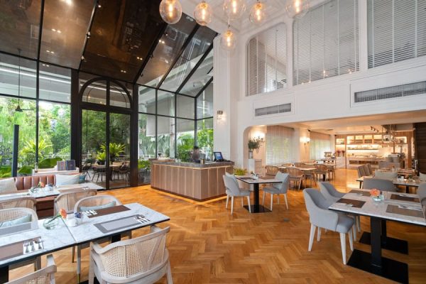 Bright restaurant with an open kitchen, buffet counter and garden-facing dining tables