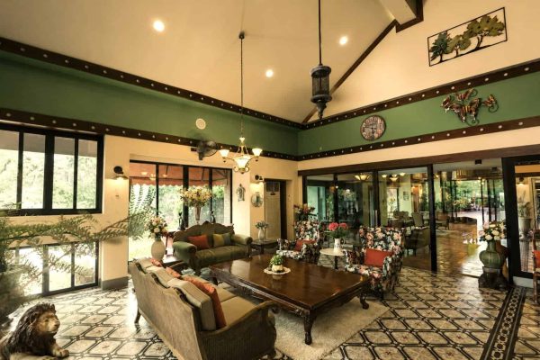 Spacious green sitting hall with sofas and garden doors for group reflection and conversation