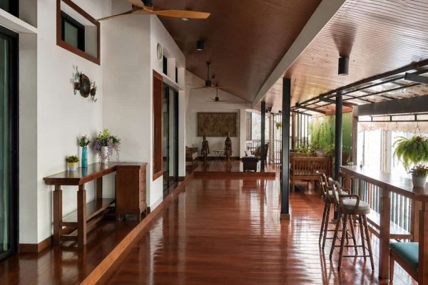 Long covered teak terrace with fans and seating for private group wellness activities