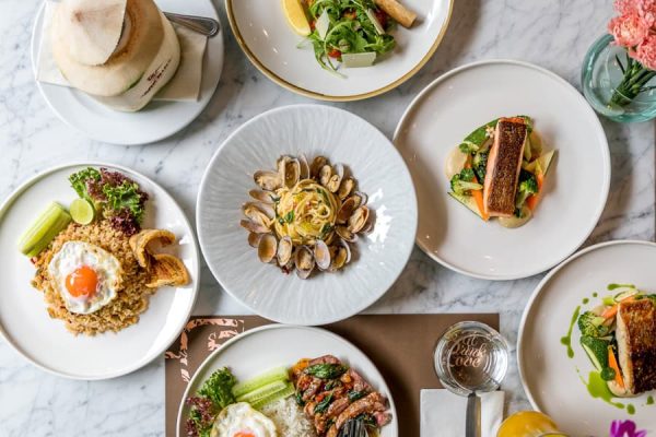 Overhead table filled with colourful Thai and international dishes