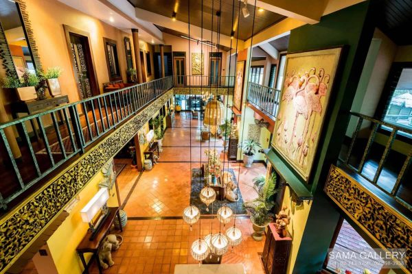 Upper-level view across a warm teak atrium prepared for a private group wellness retreat in Bangkok