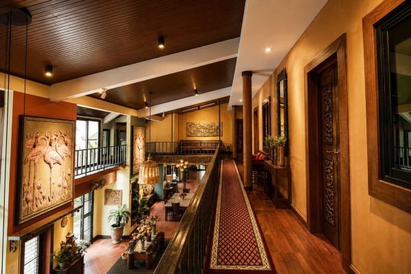 Carpeted upper corridor overlooking the central atrium of a private retreat house