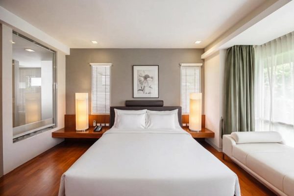 Bright private guest room with a double bed and window seat for a Bangkok wellness retreat