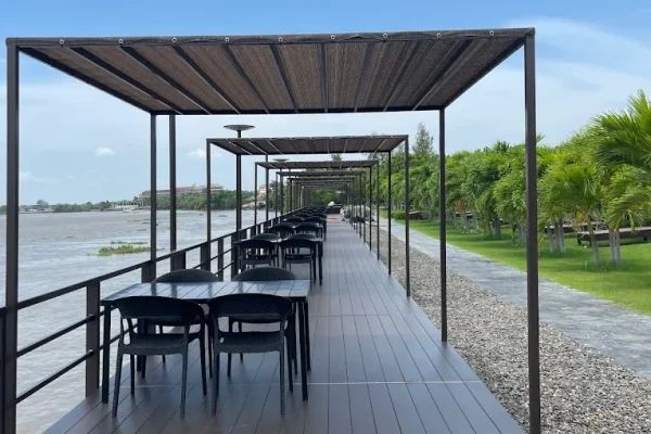 Waterfront outdoor dining area with shaded seating and scenic nature views - River lunch Sanpudard