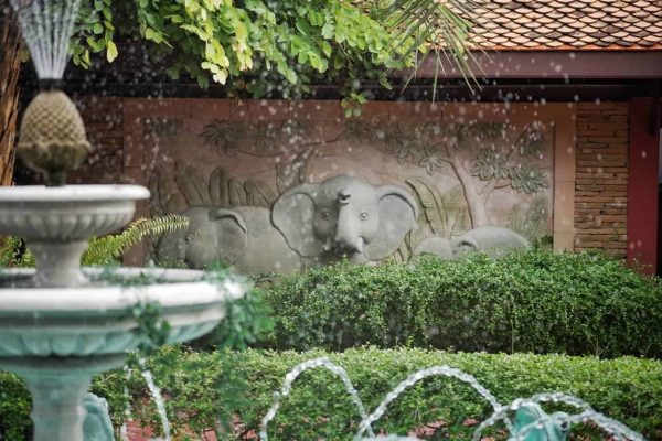 Elephant wall relief behind a fountain in the tropical retreat garden