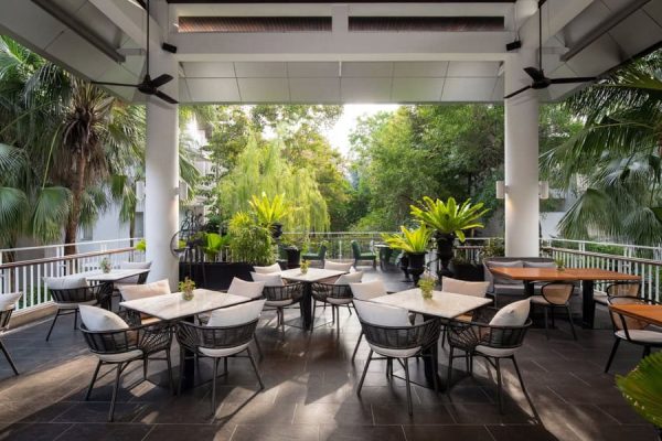 Covered open-air restaurant terrace surrounded by trees at the group's wellness accommodation